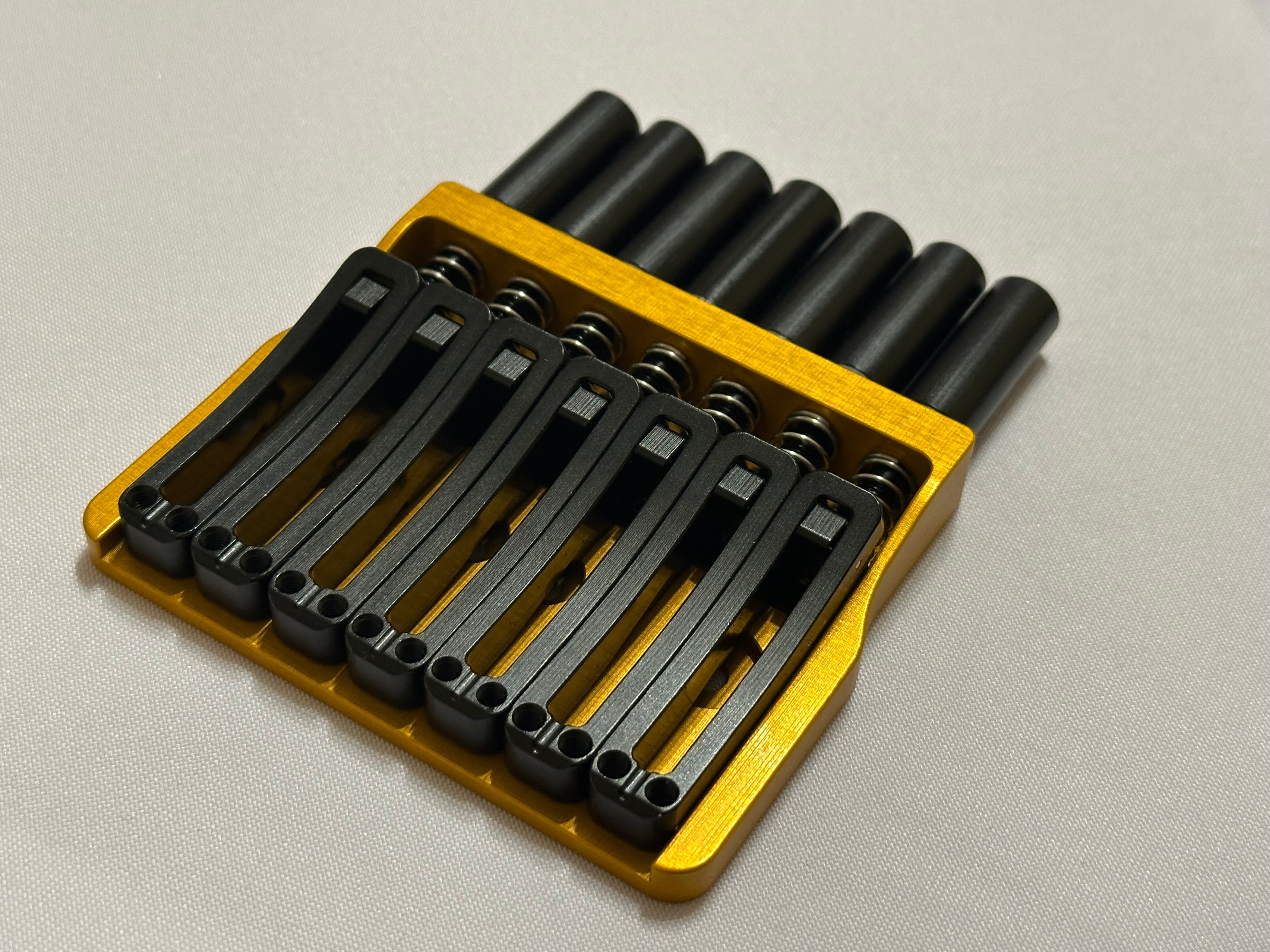 Rakhvari 7 String Hardtail Bridge - Gold Baseplate / Black Hardware